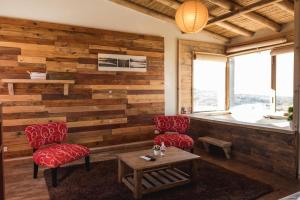 een kamer met houten wanden, 2 stoelen en een tafel bij CASAS VIEJAS LODGE in La Cumbrecita