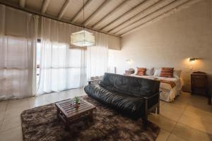 een woonkamer met een bank en een bed bij CASAS VIEJAS LODGE in La Cumbrecita
