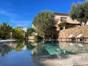 uma piscina em frente a um edifício com árvores em Villa Anna em Begur