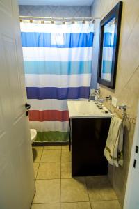 a bathroom with a sink and a colorful shower curtain at Altos de Manantiales in El Calafate +17 photos