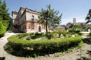 an old house with a garden in front of it at Hotel Iris in Perugia