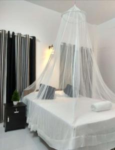 a bedroom with a white bed with a mosquito net at CLIFF HEAVEN Apartment in Varkala +118 photos