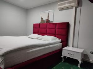 a bed with a red headboard in a room at Leoton Chernivtsi in Chernivtsi +32 photos