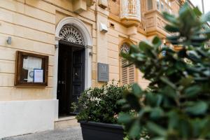 un bâtiment avec une porte noire et quelques plantes dans l'établissement Monreal Boutique Townhouse - R024RM5, à Paola