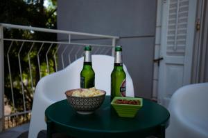 two bottles of beer and a bowl of food on a table at Villa Calipso in Mondello