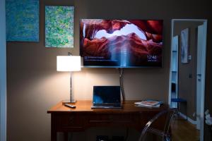a laptop on a desk with a tv on the wall at Villa Calipso in Mondello
