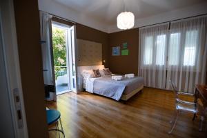 Villa Calipso في مونديلّو: غرفة نوم بسرير وباب زجاجي منزلق