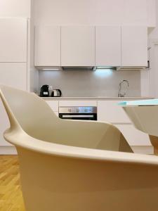 a kitchen with white cabinets and a white chair at STAY home experience in Perugia