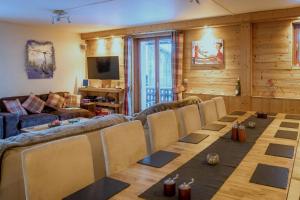 uma sala de estar com uma mesa longa e cadeiras em Chalet Aventure B&B Les Gets em Les Gets