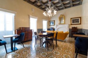 une salle à manger avec une table, des chaises et un lustre dans l'établissement Monreal Boutique Townhouse - R024RM6, à Paola