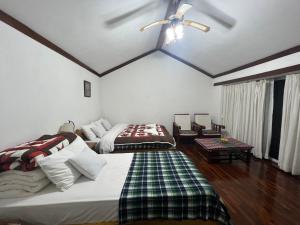 una camera da letto con due letti e un ventilatore a soffitto di ES Deurali Resort a Pokhara
