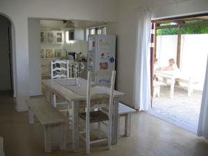a kitchen with a table and a refrigerator at Karoo Huis in Arniston