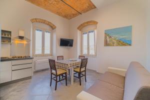 a kitchen and dining room with a table and chairs at Appartamenti Brezza Marina a Campo in Marina di Campo