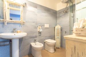 a bathroom with a sink and a toilet and a mirror at alloggio turistico VistAmare (il guardiano del faro) in Focene