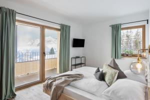 um quarto com uma cama e uma grande janela em Holzhackerin - the charming Haus am Berg em Schladming