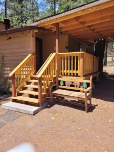 a wooden cabin with a staircase and a porch at Greer Point Trails End Cabins in Greer