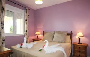 dwa łabędzie siedzą na łóżku w sypialni w obiekcie Apartamento en Torrox: 2 dormitorio wifi y piscina w mieście Torrox