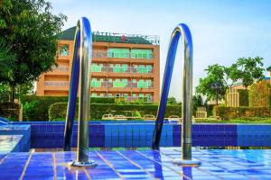 a swimming pool with blue tiles and a building at Hotel Univers 3 Aeroport Luxe in Niamey