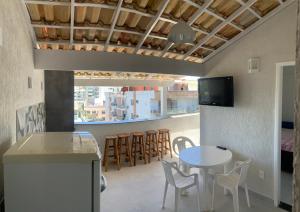 cocina y comedor con mesa y sillas en Cobertura na praia do forte - Cabo Frio, en Cabo Frío