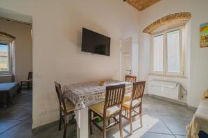 坎普码头Appartamenti Brezza Marina a Campo的一间带桌椅和电视的餐厅
