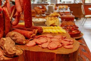 um buffet de carnes e outros alimentos sobre uma mesa em Hotel Village da Serra em São Francisco de Paula
