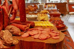 un buffet de carnes y otros alimentos en una mesa en Hotel Village da Serra, en São Francisco de Paula