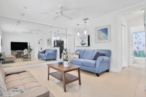 a living room with two blue couches and a table at Kaslo Breeze in Vero Beach