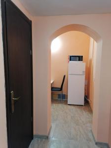 ブダペストにあるKeleti Apartmentsの冷蔵庫とテーブル付きの部屋へのドア
