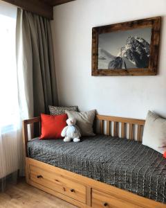 a teddy bear sitting on a bed in a bedroom at Karwendel-Lodge in Scharnitz