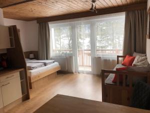 Pokój z łóżkiem, kanapą i oknami w obiekcie Karwendel-Lodge w mieście Scharnitz