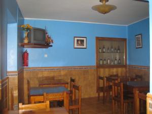 a restaurant with blue walls and wooden tables and chairs at Hotel Chola in Dorna