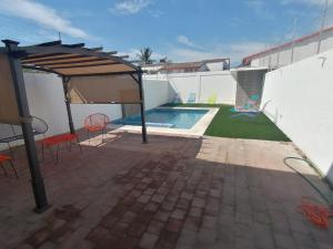 un patio con piscina y sombrilla en ACAPULCO DIAMANTE NUEVA E INCREIBLE VILLA CON ALBERCA PROPIA en Acapulco