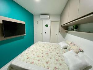 ein Schlafzimmer mit einem Bett und einem Fernseher an der Wand in der Unterkunft Muro Alto Condomínio Clube Apto 219 in Ipojuca + 30 Fotos