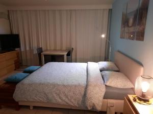 een slaapkamer met een groot bed en een tafel bij Studio with sea view and panoramic view in Bredene in Bredene