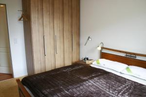 een slaapkamer met een groot bed en een houten kast bij Wohnpark Niendorf Wohnpark Niendorf Appartement 39 in Niendorf