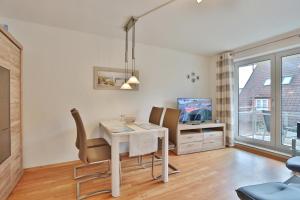 a living room with a table and chairs and a tv at Seesternresidenz Seesternresidenz Appartement 8 in Scharbeutz