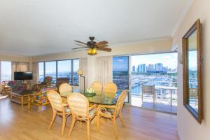a dining room with a table and chairs and a balcony at Ilikai Tower 943 Yacht Harbor View 2BR in Honolulu