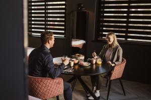 Ein Mann und eine Frau sitzen an einem Tisch in der Unterkunft Oldschool Hotel in Winterswijk