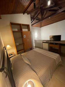 a bedroom with a bed and a desk with a laptop at Hotel Vila Serrana in Sete Lagoas +42 photos