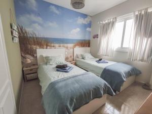 a bedroom with two beds and a painting on the wall at Casa Chinijo in Famara
