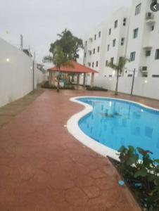 a swimming pool in front of a building at Reposo Tranquilidad cerca del corazón de Santiago in Santiago de los Caballeros