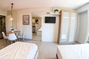a bedroom with two beds and a table and a room at RESIDENCIAL MAR BLUE in Bombinhas
