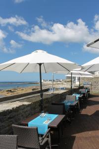ル・ギルヴィネックにあるル ポアソン ドールアヴリルの浜辺の傘をさすテーブル