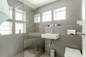 a bathroom with a toilet and a sink and a shower at The Ley @ The Sea in Kalk Bay