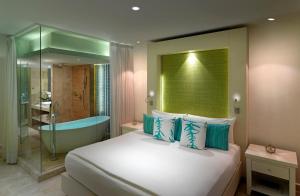 a bedroom with a bed and a bathtub and a bed and a bathroom at Paradisus Cancun All Inclusive in Cancún