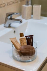 a bathroom counter with a bowl of cosmetics on a sink at Yes I Know My Room - Magica Napoli in Naples
