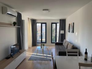 een woonkamer met een bank en een tafel bij Brand new apartment with outdoor swimming pool in Varna