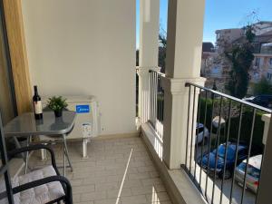 een balkon met een tafel en een fles wijn bij Brand new apartment with outdoor swimming pool in Varna