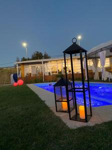 een nachtscène van een zwembad met een lantaarn naast een gebouw bij Hotel Terrazas del rio Negro in Pueblo Centenario