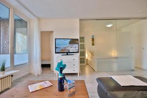 ein Wohnzimmer mit einem TV und einem Sofa in der Unterkunft Strandresidenz Timmendorfer Strand Strandresidenz Appartement 108 in Timmendorfer Strand